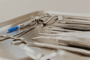 Sterile dental instruments and an anesthetic syringe prepared for a dental procedure.